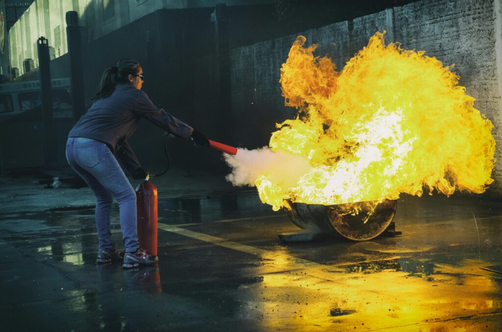 Woman putting out fire with a fire extinguisher